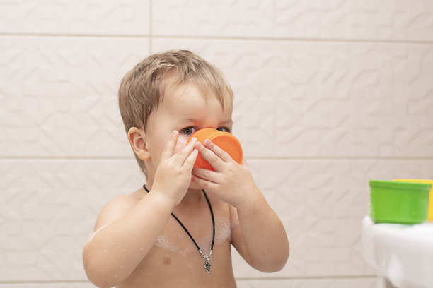 快乐的小男孩在浴缸里洗澡。特写镜头。软的焦点。儿童保育的概念。图片下载