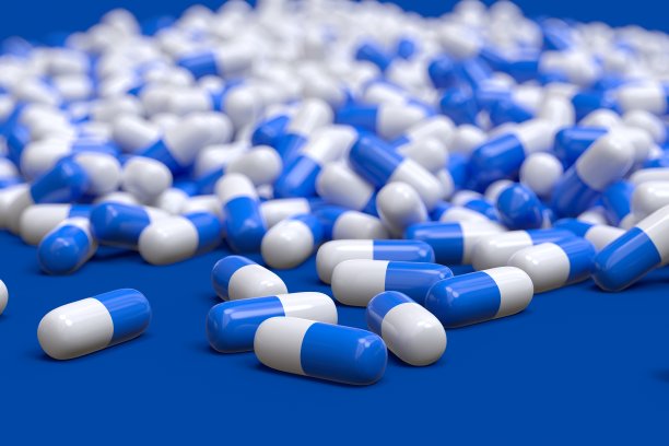 蓝色和白色的药物胶囊3D电脑生成孤立在蓝色背景上图片下载