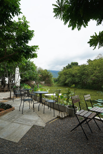 餐厅露台和咖啡厅的户外用餐空间区域，自然的绿色湖泊景观和多云的天空图片下载