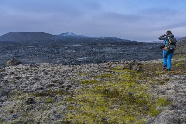 拍摄Fagradalsfjall火山喷出的熔岩的妇女图片下载