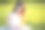 一个女孩在阳光明媚的日子里坐在格子花呢上，在一片绿草茵茵的田野里看书图片下载
