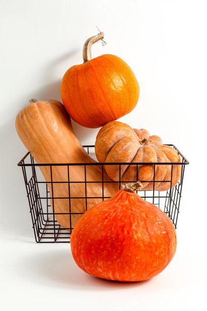 在白色背景的篮子里堆不同的南瓜。副本的空间。图片下载