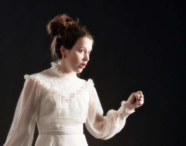 年轻女子身着维多利亚蕾丝裙，姿态优雅，神情焦虑图片下载