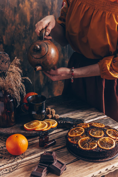 女人把茶倒进杯子里。复古的风格。图片下载