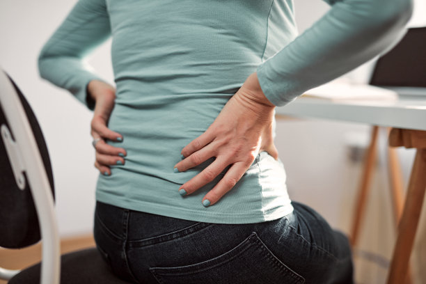 妇女髋关节，背部，脊柱痉挛，抽筋和疼痛，工作从家庭问题和问题。图片下载