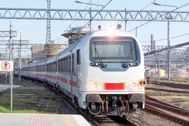 一辆白色客运列车从城市车站驶来。图片下载