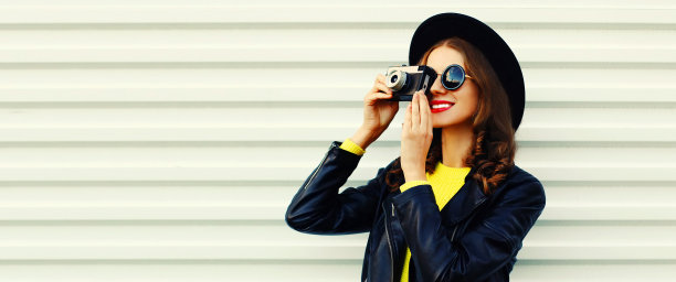 快乐微笑的年轻女子摄影师的肖像与电影相机在白色背景图片下载