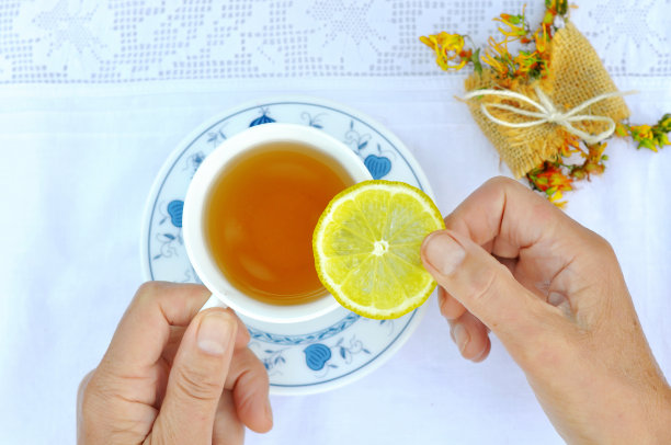 女人手拿饼干喝草药热茶图片下载