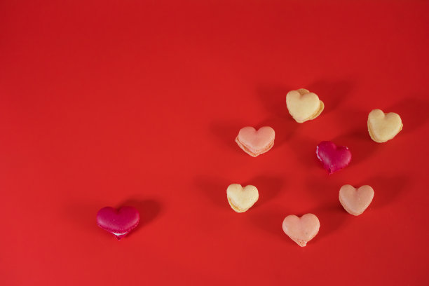 在红色的背景上平铺心形马卡龙图片下载