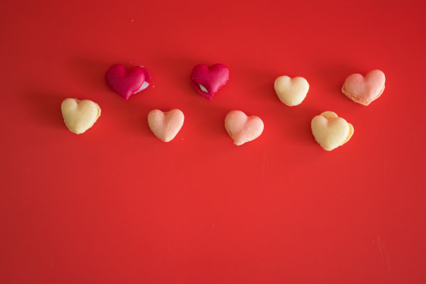 在红色的背景上平铺心形马卡龙图片下载