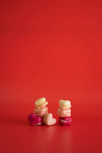 在红色的背景上平铺心形马卡龙图片下载