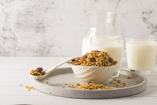 燕麦卷碗，里面有葡萄干，坚果和新鲜浆果。自制脆麦片在灰色混凝土背景，俯视图图片下载