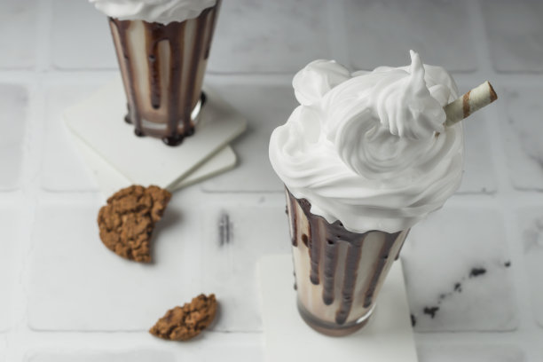 甜点饮料。巧克力奶昔配上鲜奶油，在浅底的高脚杯里放上稻草饼干。有选择性的重点图片下载