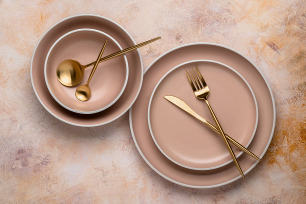 收集不同大小的圆形米色盘子在桌子上，俯视图。用于服务和用餐的金色餐具和陶器。现代工艺陶瓷餐具，新潮餐具。图片下载