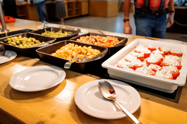 酒店的自助自助餐，在covid - 19限制期间，游客从开放的托盘中收集食物图片下载