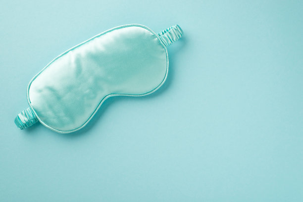 俯视图照片的一个有吸引力的大蓝色丝绸和豪华的面具睡觉坐落在柔和的浅蓝色孤立的背景后台空间图片下载