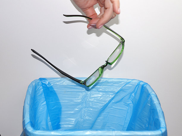 女性手把老花镜扔进垃圾桶图片下载