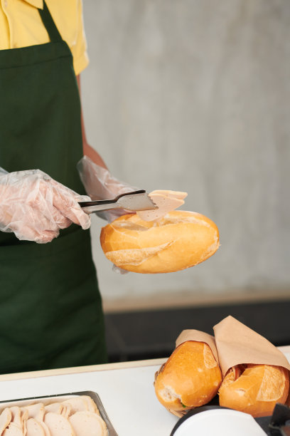 把火鸡火腿片放进面包里的小贩图片下载