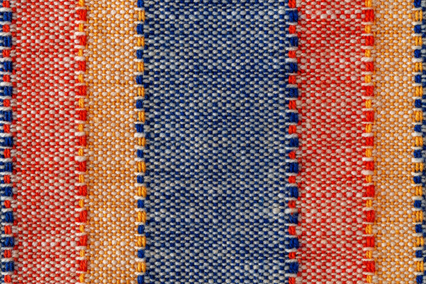 平纹织物的宏观纹理。红色，蓝色，橙色和白色的条纹布背景。织物帆布表面特写。彩色织物的设计元素。纬和扭曲。图片下载