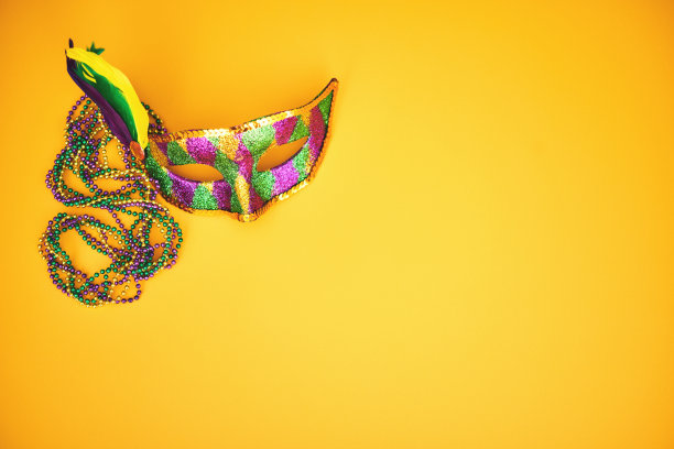 狂欢节背景与彩色珠子和威尼斯面具在黄色背景图片下载