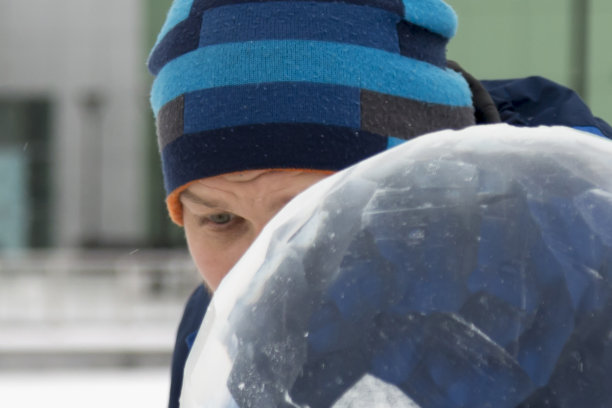 一个雕刻家的肖像，穿着蓝色的冬装，手里拿着凿子在工作图片下载