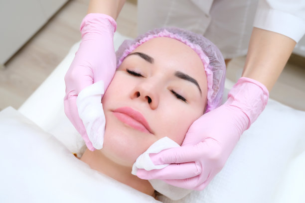 美容。可爱的年轻女子闭着眼睛接受面部清洁程序的特写照片图片下载