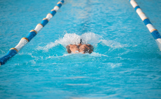 这张照片拍摄的是一名不知名的年轻男运动员在一个奥运会规格的游泳池里游泳图片下载