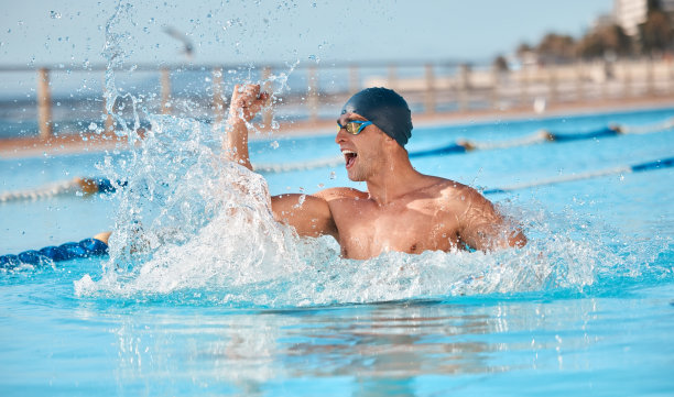 这张照片拍摄的是一个英俊的年轻男运动员在一个奥运会规格的游泳池里游泳图片下载