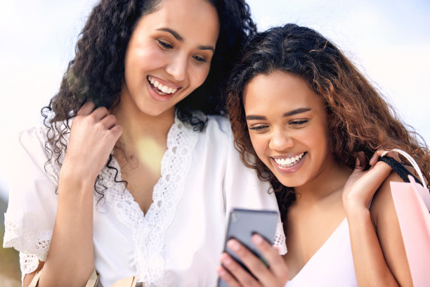 两个年轻朋友购物时用手机的照片图片下载