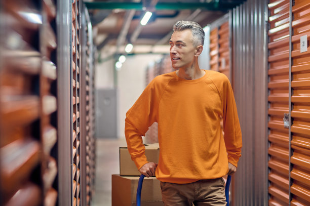 中年仓库装载机站在集装箱中间图片下载