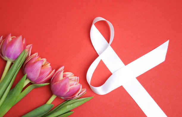 粉色郁金香和红色背景的白色丝带上的数字8。3月8日。图片下载