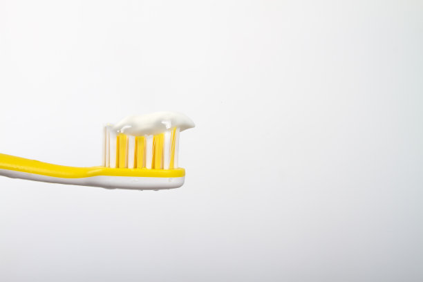 黄色牙刷，白色牙膏，刷毛，白色背景图片下载
