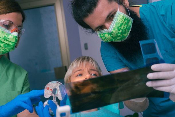 年轻男女牙医向他们的病人展示她牙齿的x光照片图片下载