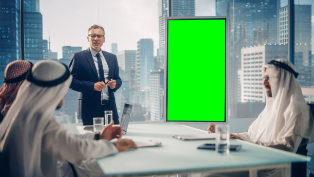 国际经理为沙特商业伙伴举行会议演示。专家使用垂直绿色屏幕模拟显示的白板。沙特，阿联酋，阿拉伯办公室概念。图片下载