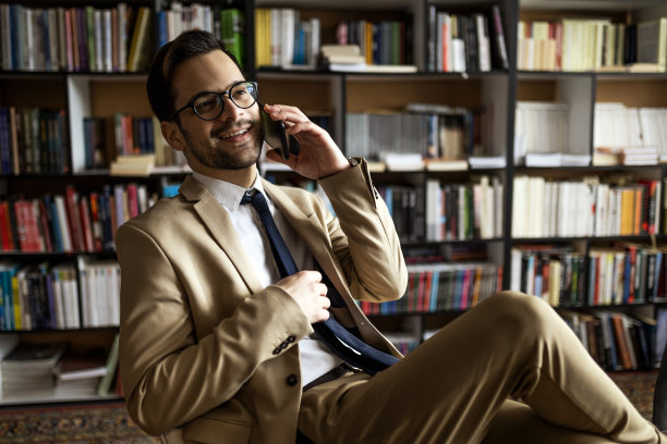 一个商人在图书馆用智能手机聊天图片下载