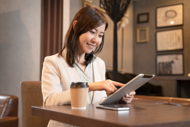 一个女人在咖啡馆里操作平板电脑图片下载