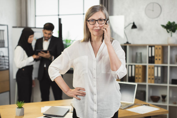 白人女性在办公室用手机通话图片下载