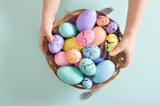 复活节卡片。极简主义。孩子们手里拿着一个篮子，上面画着复活节彩蛋和羽毛。图片下载