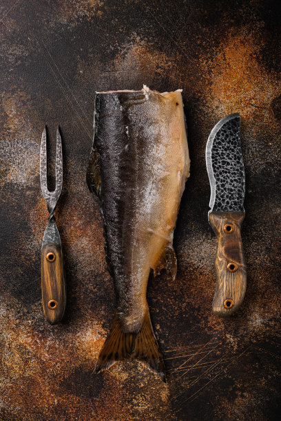 烟熏整条鲑鱼，在古老的深色质朴的桌子背景上，俯视图平躺图片下载