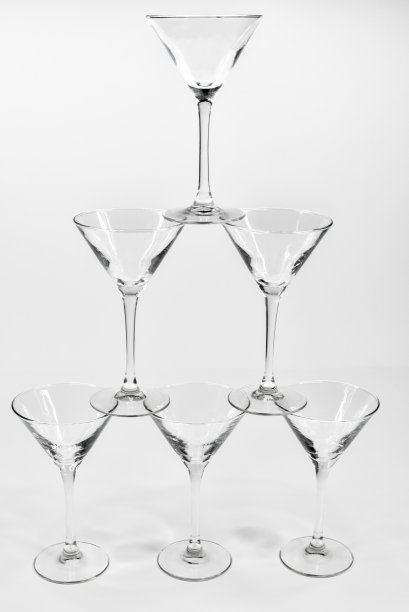 空的马提尼鸡尾酒杯在白色的背景下相互顶着图片下载