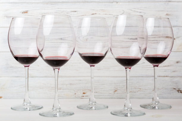 品酒时喝了好几杯红酒。红酒在有色背景上的概念。俯视图，平面设计图片下载