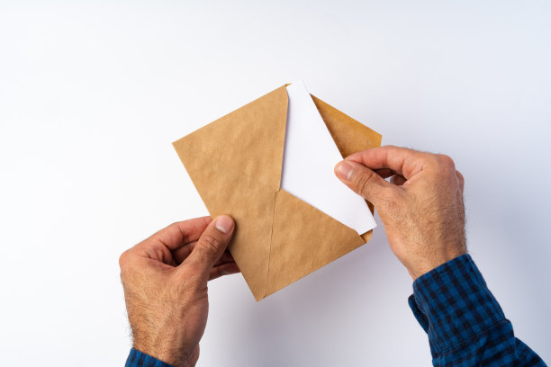 俯视图男性手握(打开)信封上面的白色背景图片下载