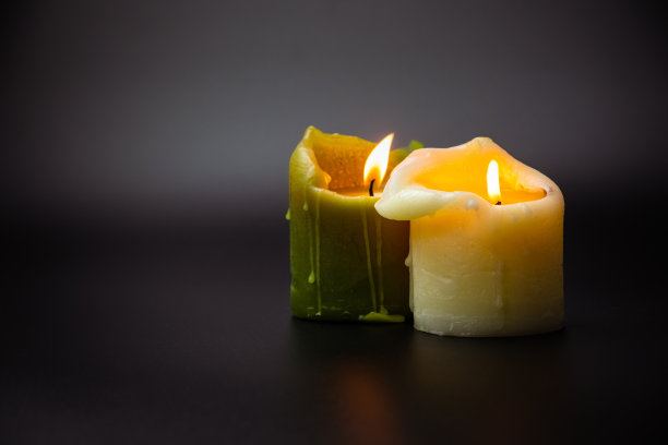美丽的燃烧蜡烛在黑色背景与复制空间。绿色和白色的香味蜡烛。自然的蜡烛图片下载