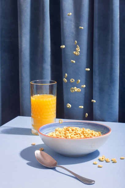 掉落的燕麦片在蓝色背景和果汁上呈环状图片下载