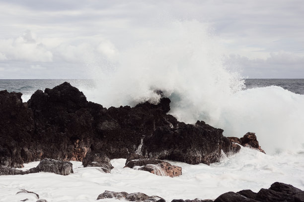 飞溅的波浪撞击熔岩岩石图片下载
