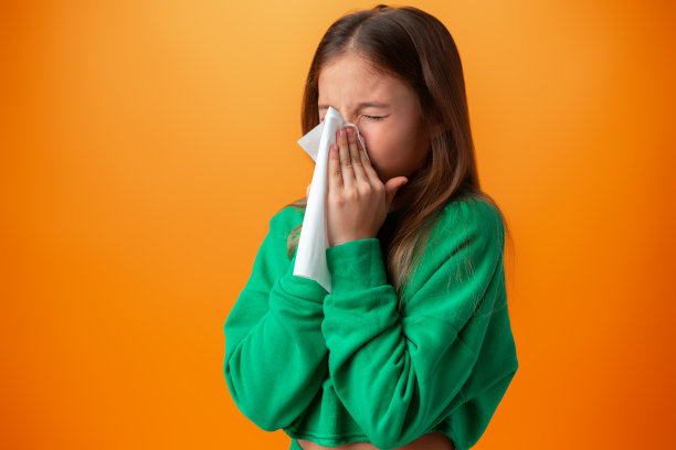 少女对着橙色背景擤鼻涕图片下载