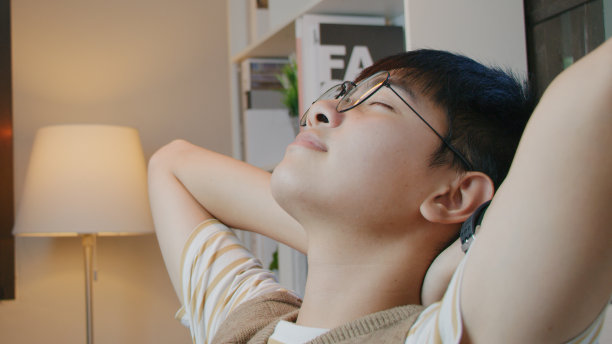 亚洲青少年闭上眼睛，坐在椅子上休息，他的眼睛和放松他的头脑一会儿图片下载