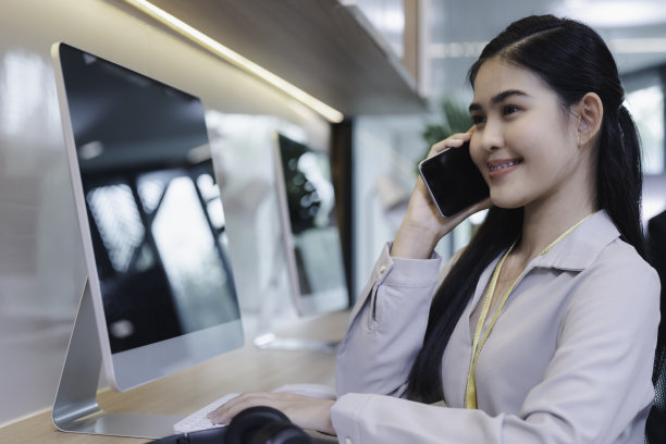 年轻的商务女性在现代的办公室里用智能手机打电话图片下载