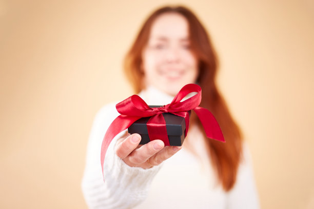 女性手中礼物盒的特写照片。拿着礼盒的女人。情人节。生日或节日的概念。本空间图片下载