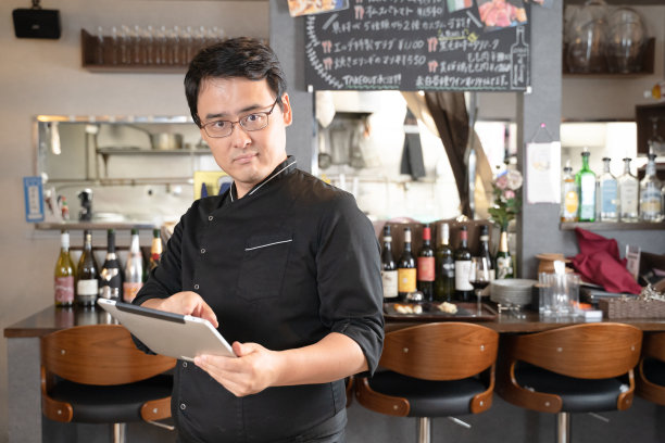 男性员工在餐厅使用平板电脑图片下载